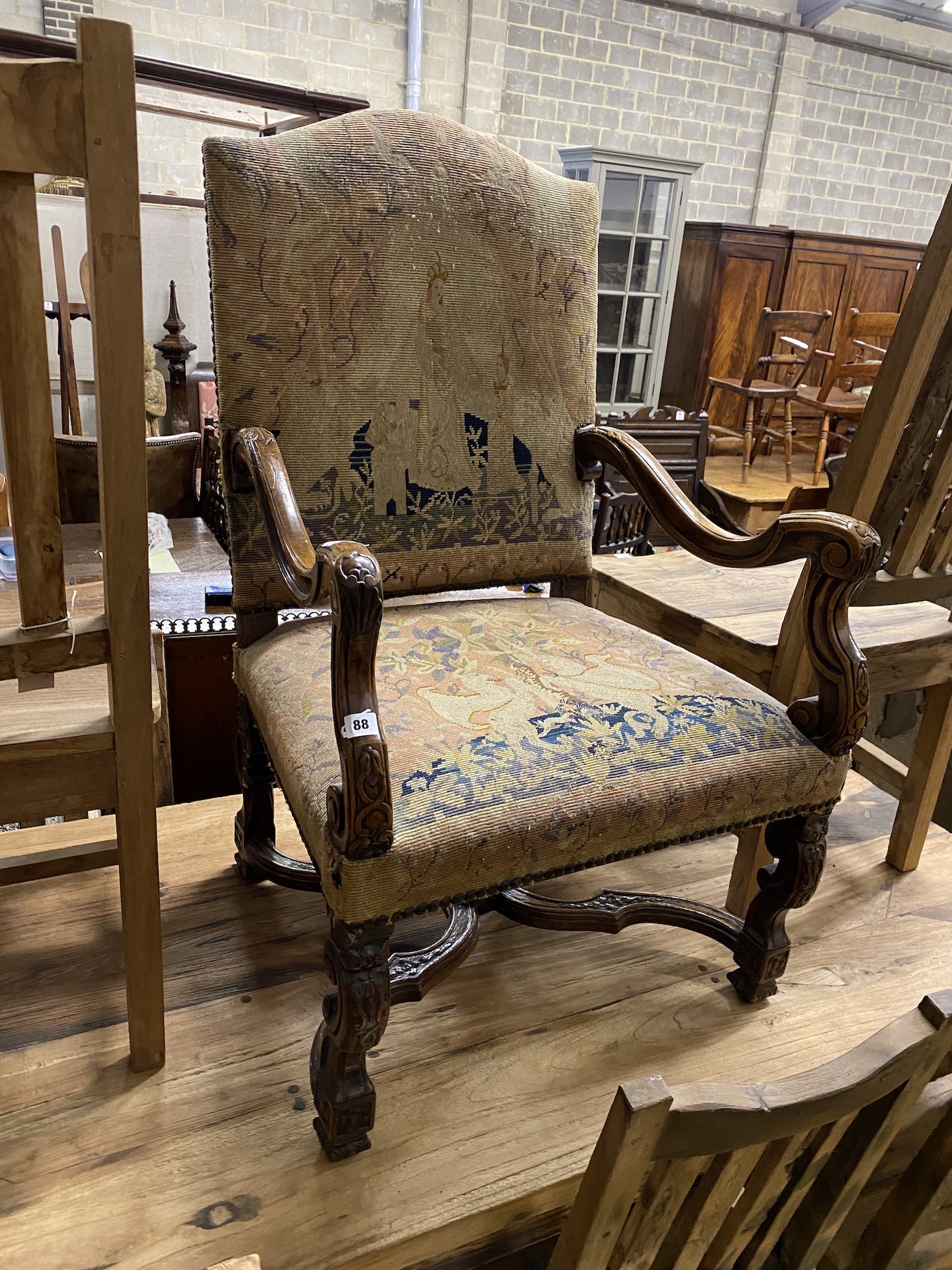 An upholstered carved walnut elbow chair, width 69cm, depth 60cm, height 110cm